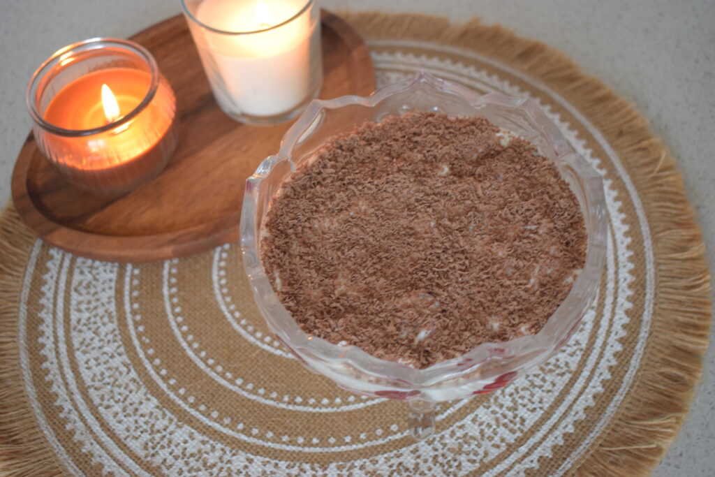 Homemade no-bake tiramisu dessert with fresh cherries, creamy layers, and chocolate shavings